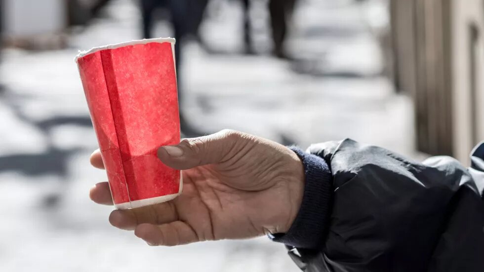 ausgestreckte Hand, die Pappbecher hält